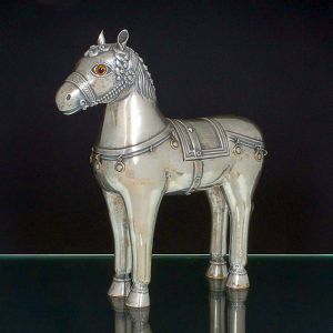 <b>LUIZ FERREIRA</b> - Estatueta representando <b>cavalo de Tróia </b>com seus característicos paramentos e compartimento rebatível em seu dorso. Faltam duas medalhinhas decorativas e crina do cavalo. Contraste da cidade do Porto e do referido prateiro. Teor 833 ml. Alt. 33 cm; Compr. 29,5 cm. Peso 1140 gramas.