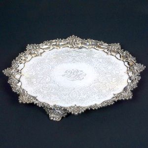 Belíssima <b>salva </b>circular em prata inglesa vitoriana, apresentando fundo lavrado com volutas e flores centralizando elaborado monograma. Borda em composição concheada, assim como os pés. Contrastes da cidade de Londres de 1849 e marca do prateiro JOSEPH ALBERT SAVORY. Diâm. 46 cm. Peso 2330 gramas.