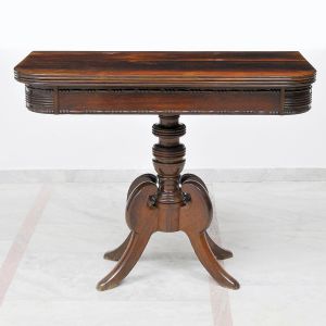 <B>Console</B> brasileiro no estilo Império, reversível para mesa de jogo, construído em jacarandá. Tampo reclinável com cercadura em boleados, coluna central em segmentos de balaústre torneados e quatro pernas recurvadas. Séc. XIX. Med. fechado 77 x 96,5 x 46,5 cm; Med. aberto 77 x 96,5 x 94 cm 