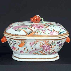 <B>Sopeira </B>de forma retangular e cantos chanfrados em porcelana Companhia das Índias decorada em rica policromia nos esmaltes da Família Rosa com grandes botões floridos e pergaminhos. Pegas do bojo modeladas em cabeças de lebres e da tampa em romã. Séc. XVIII. Med. 21,5 x 33 x 23 cm