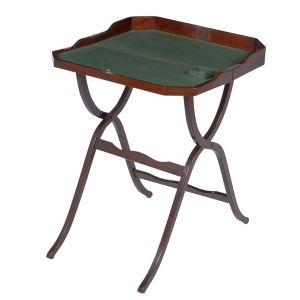 Invulgar <B>"bureau" de viagem </B>inglês em mogno apresentando tampo pivotante com interior em couro verde pirogravado a ouro. Pernas articuláveis em "X" ondulado unidas por dois travessões de alturas diversas. Selo do fabricante J. C. Vickery to Her Majesty - 179 Regent Street.