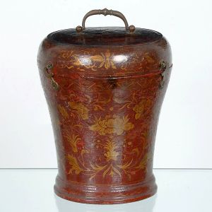 <B>Urna oriental</B>, de formato abaulado, em madeira revestida por rica laca vermelha com decoração em douração, apresentando grandes flores de lótus, folhagens estilizadas e padrões sinuosos. Tampa destacável com alça metálica torneada e ferragens laterais originais. Alt. 20 cm