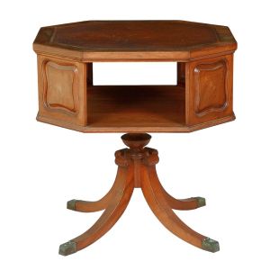 <b>Mesa auxiliar </b>conhecida como "library table" inglesa. Apresenta caixa sextavada com tampo revestido em couro, este com marcas do tempo. Segmentos em almofadados movimentados intercalados com vão para livros. Pernas recurvadas terminadas em ponteiras metálicas. Séc. XIX.