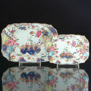 <b>Conjunto de duas travessas </b>de forma retangular com cantos chanfrados em porcelana Companhia das Índias, decoradas em policromia no conhecido padrão "Folha de Tabaco", apresentando figura de "Guanyn" cercada por rica policromia florida. Séc. XVIII. Compr. 25 e 19 cm
