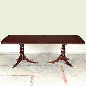 Antiga <b>mesa de jantar </b>elástica em madeira nobre escurecida, apresentando tampo retangular sobre duas colunas torneadas em forma de balaústre. Pés arqueados terminados em ponteiras metálicas. Med. 75 x 220 x 110 cm; Med. com a tábua extensora 75 x 260,5 x 110 cm