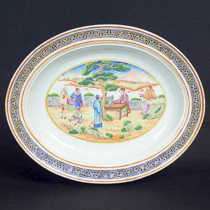 Rara <b>travessa </b>de forma oval em porcelana Companhia das Índias decorada em policromia nos esmaltes da Família Rosa, pertencente ao "Serviço dos Correios", de D. João VI. Borda em gregas azuis com filetados em "rouge de fer" e ouro. Séc. XVIII. Med. 37,5 x 30,5 cm