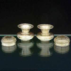 <b>Lote em prata </b>portuguesa "Águia", teor 833 ml, constando de par de pequenas caixas circulares com tampas cinzeladas com arabescos e par de mini jarras com parte inferior bojuda e bocal de corneta. Diâm. das caixinhas 6 cm; Alt. dos vasinhos 6 cm. Peso 295 gramas.