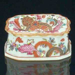 <b>Saleiro </b>de forma retangular com parte superior funda e borda recortada em porcelana Companhia das Índias em policromia nos esmaltes da Família Rosa numa variação do padrão "Folha de Tabaco", conhecida com "Folha de Chá". Séc. XVIII. Med. 8 x 6 x 3,5 cm