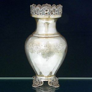 <b>Vaso </b>bojudo em prata portuguesa. Aba e pés em vazados com figuras de cervos e centro do bojo gravado com flores e folhas. Contraste da cidade do Porto usado a partir de 1938 e teor 833 ml. Algumas mossas no centro do bojo. Alt. 25 cm. Peso 575 gramas.