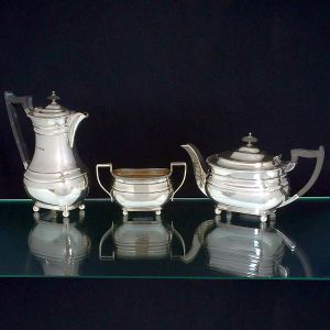 <B>Conjunto de bule de café, bule de chá e açucareiro </B>em prata inglesa lisa com bordas frisadas e pés em bolas. Alças dos bules em madeira. Contraste da cidade de Sheffield de 1947 e marca de prateiro. Alt. do bule de café 23,5 cm. Peso 1700 gramas.