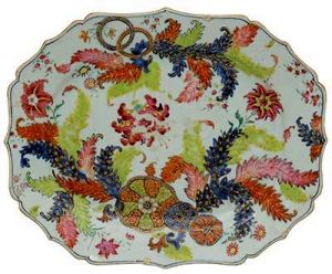 <b>Travessa </b>de forma retangular e cantos chanfrados em porcelana Companhia das Índias decorada em rica policromia florida no padrão "Folha de Chá". Predominância das tonalidades de rosa, azul, verde e "rouge de fer". Séc. XVIII. Med. 38 x 31 cm