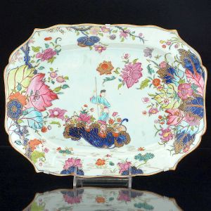 <b>Travessa </b>de forma retangular com cantos chanfrados em porcelana Companhia das Índias decorada em policromia no conhecido padrão "Folha de Tabaco", apresentando figura de "Guanyn" cercada por rica policromia florida. Séc. XVIII. Compr. 34 cm