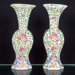 <B>Par de vasos </B>de formato balaústre, em porcelana chinesa, decorados com ramos floridos, pássaros e folhagens em tons de rosa, verde, azul e amarelo, distribuídos sobre fundo branco esmaltado. Base octogonal suavemente elevada. Alt. 25 cm