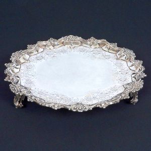 Bela <b>salva</b>  circular em prata portuguesa. Aba recortada com flores, angras e acantos. Centro liso com borda gravada por flores. Triplos pés vazados. Contraste da cidade de Lisboa. Provavelmente do séc. XVIII. Diâm. 31,50 cm. Peso 725 gramas.