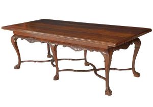 <b>Mesa de jantar </b>brasileira em jacarandá. Tampo retangular de cantos arredondados e saia movimentada entalhada com volutas. Pernas recurvadas terminadas em sapatas e unidas por travessões ondulatórios em "X". Séc. XIX. Med. 79 x 240 x 105 cm