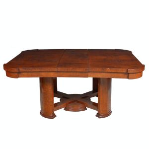 Bela <b>mesa europeia </b>Art Déco, em nogueira, construída no sistema elástico. Tampo retangular com cantos arredondados. Pernas facetadas unidas por travessão em "X" centralizando elemento circular. Início do séc. XX. Med. 77 x 233 x 120 cm