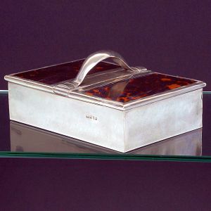 Grande <b>caixa para charuto </b>em prata inglesa lisa. Apresenta duas tampas rebatíveis, forradas em tartaruga, com robusta alça central. Contraste da cidade de Birmingham de 1904. Prateiro EC. Compr. 28,5 cm; Alt. 13,5 cm; Larg. 20 cm