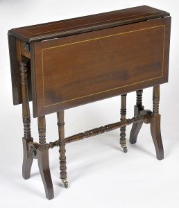 Pequena <b>mesa de apoio </b>dita "gate-leg", em mogno, no estilo inglês. Tampo com duas abas reclináveis decorado com frisos e pernas torneadas, tendo as móveis, rodinhas.  Med. aberta 65 x 64 x 72 cm; Med. fechada 65 x 64 x 14 cm