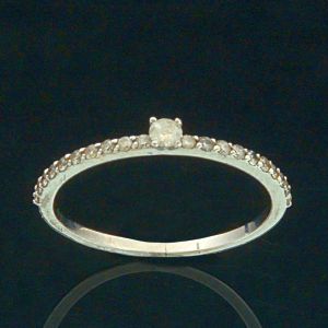 <b>Anel </b>solitário em base de aliança montado em ouro branco 18k com 21 brilhantes, sendo um diamante no centro com o peso aproximado de 0,6 ct e 20 brilhantes menores com o peso aproximado de 0,20 ct. Peso da peça 1,24 gramas.