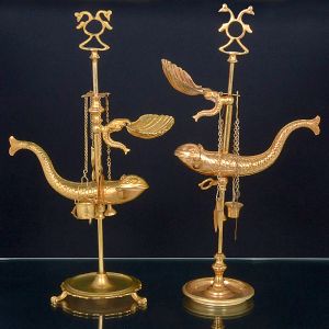 <b>Conjunto de 2 antigos candeeiros </b>possivelmente franceses, Império, em bronze dourado. Decoração com motivos marinhos, altura regulável e um deles com pés em garras. As bases são ligeiramente diferentes. Séc. XIX. Alt. 47 cm