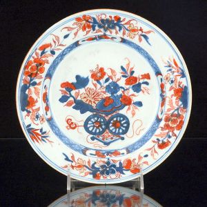 <b>Prato </b>circular em porcelana Companhia das Índias, decorado em policromia no padrão chinese Imari com suas tonalidades característica de azul índigo e "rouge de fer" com discretos realces a ouro. Séc. XVIII. Diâm. 22,5 cm