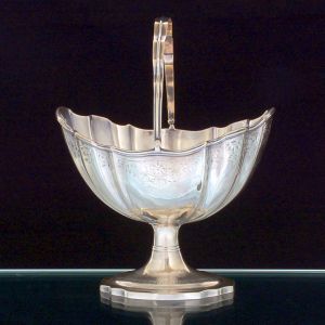 <b>Cesta </b>navicular em prata irlandêsa George III. Apresenta forma navicular recortada e delicadamente lavrada com elementos fitomórficos. Contraste da cidade de Dublin de 1800. Compr. 17,5 cm; Alt. 15,5 cm. Peso 370 gramas.