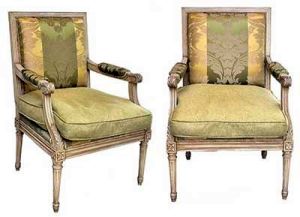 <b>Par de cadeiras de braços </b>francesas, no estilo Louis XVI. Estrutura em madeira patinada em bege e entalhada com volutas e rosetas. Pernas retilíneas com escavados verticais. MAISON JANSEN - Paris. Med. 94 x 64 x 65 cm