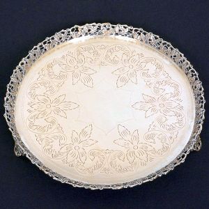 <b>Salva</b> circular em prata portuguesa. Fundo lavrado e aba com vazados de uvas e folhas de parreira. Triplos pés estilizados. Contraste da cidade do Porto e vestígios de marca de prateiro. Diâm 27 cm. Peso 650 gramas.