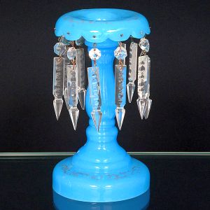 <b>Castiçal </b>em opalina francesa na cor turquesa. Base circular com vestígios de ramagens dourada. Hastes em segmento de balaústre com bocal revirado para fora no qual pendem ponteiras de cristal Baccarat. Alt. 24 cm