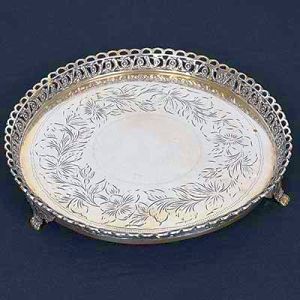 <b>Salva </b>circular em prata portuguesa. Fundo lavrado com flores e borda com flores, volutas e semicírculos. Pés em garras ladeadas por volutas. Marca da cidade do Porto e de prateiro. Diâm. 25,5 cm. Peso 550 gramas.