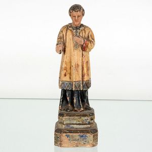 Imagem de <B>coroinha de altar </B>em madeira, caracterizada por pátina preta com sobrepeliz patinada em bege debelada em azul. Vestimentas exatamente usadas por coroinhas em missas tradicionais. Séc. XIX. Alt. 21,5 cm