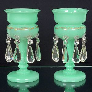 <b>Par de vasos </b>de corpo bojudo, em vidro opalinado na cor verde e haste torneada. Apresentam aplicação de rosetas em vidro translúcido ao redor da parte superior, além de friso decorativo em douração. Alt. 31 cm