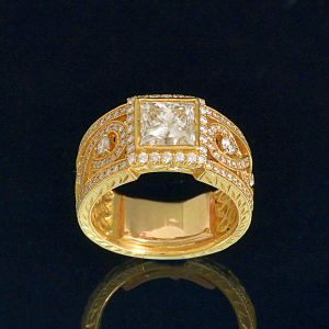 <b>Anel </b>de diamantes montado em ouro 18k com um diamante "princess cut" com o peso aproximado de 2,00 ct e diamantes menores redondos com o peso total aproximado de 1,00 ct. Peso total da peça 12,27 gramas.