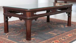 Antiga <b>mesa de centro </b>chinesa de forma retangular em madeira nobre. Apresenta cantos arredondados e saia vazada. Pernas cilíndricas retas e protetor do tampo em vidro. Med. 36 x 100 x 50 cm