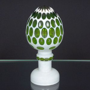<B>Pinha </B>em cristal, ornamentada em "overlay" verde, com elementos ovais revelando a camada interna colorida. Base com anel central formado por aplicações ovais no mesmo padrão. Alt. 23,5 cm