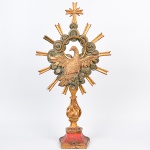 <b>MESTRE PIRANGA</b><Br>Grande imagem do <b>Espírito Santo </b>em madeira entalhada com bela policromia e douração cercada por enrolados de nuvens e raionados. Cruz ao topo e base em vermelho. Séc. XVIII. Alt. 90 cm