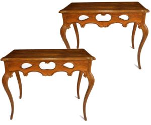 Antigo <b>par de consoles </b>retangulares e brasileiros em madeira nobre apresentando saia movimentada decorada com vazados à frente e nas laterais. Pernas recurvadas. Med. 84 x 105 x 57 cm
