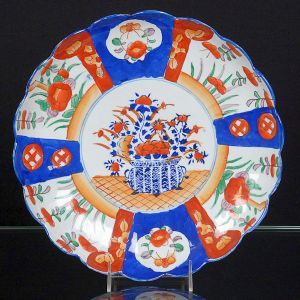 <b>Medalhão</b>  em porcelana japonesa Imari. Apresenta borda em ondulações e policromia característica com cesto de flores e reservas com flores e folhas. Séc. XIX / XX. Diâm. 31 cm