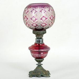 Antiga <b>lamparina </b>adaptada para "abatjour", apresentando candeeiro e cúpula em cristal na cor uva com lapidados geometrizados translúcidos. Montagem em bronze. Alt. 42,5 cm