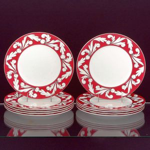 <b>Conjunto de 10 pratos </b>em porcelana inglesa Wedgwood, apresentando borda grená decorada com arabescos de volutas na cor branca delineadas por frisos em prata. Diâm. 27 cm