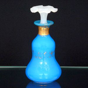 <b>Perfumeiro </b>piriforme francês em opalina turquesa com vestígios de decoração de arabescos a ouro. Tampa em forma de flor na cor branca (colada). Séc. XIX. Alt. 19 cm