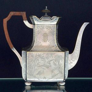 <b>Bule para café </b>em metal Elkington decorado com grous entre ramagens. Monograma em uma das faces. Pega da tampa e alça em madeira. Várias marcas no verso. Alt. 22 cm