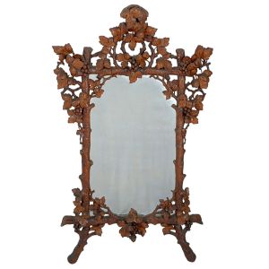 <b>Espelho </b>provavelmente português em carvalho ricamente entalhado com cachos de uvas e folhas de parreira esparramadas sobre suas cepas. Séc. XVIII. Med. 142 x 87 cm