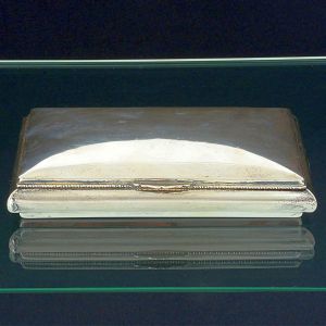 <B>Caixa para cigarros e charutos </B>em prata Sterling peruana 925 ml. Decoração lisa com tampa levemente abaulada. Prateiro CAMUSSO. Med. 22 x 13,5 cm. Peso 400 gramas.