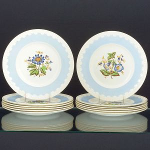 <b>Conjunto de 12 grandes pratos </b>em porcelana inglesa Wedgwood decorados com policromia de flores e borda azul lavanda com folhas de acanto em branco. Diâm. 27,5 cm