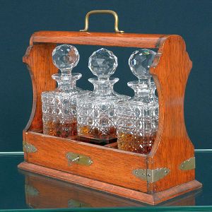 <b>Licoreiro </b>com estrutura em madeira e alça superior em metal, com ferragens aparentes. Acompanha três garrafas em cristal lapidado, com lapidações geométricas.