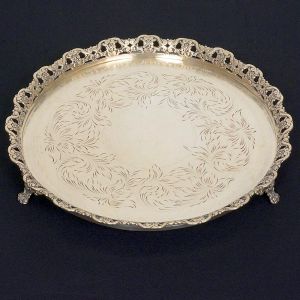 <b>Salva </b>circular em prata apresentando fundo lavrado e aba em vazados floridos. triplos pés em garras. Aparentemente sem marcas. Diâm. 25 cm. Peso 445 gramas.