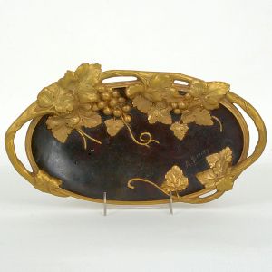 <b>A. Bouny </b>- Belo e antigo "vide poche" francês em bronze patinado e dourado decorado com cachos de uvas e folhas de parreira. Ass. à direita. Compr. 37 cm