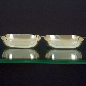 <b>Par de porta petiscos </b>em metal espessurado a prata de forma quadrada e cantos arredondados. Marca do fabricante puncionada no verso. Med. 13 x 13 cm