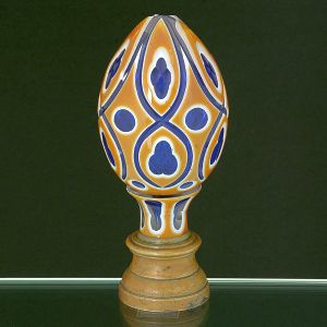 <B>Pinha </B>globular francesa em cristal azul com "overlay" em âmbar e branco. Lapidada com estilizações. Base em bronze. Séc. XIX. Alt. 18 cm